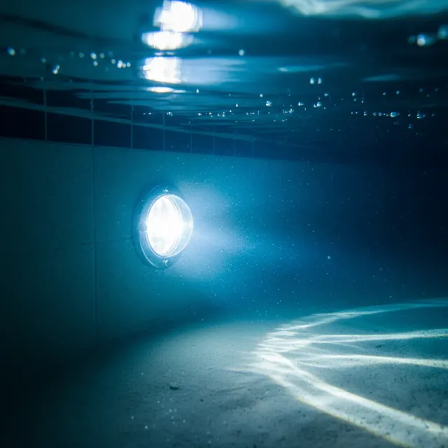 Underwater LED pool light illuminating the pool interior with a vibrant blue glow